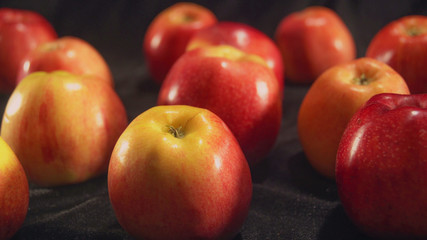 Close up colored apples on one back red on another yellow.