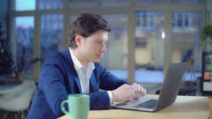 Fototapeta na wymiar Portrait caucasian thirty years man greeting client give advice or online consultation Handsome businessman wearing in fashionable jacket talking with friendly smile looking on screen laptop.