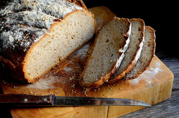 Sliced homemade rustic bread on a wooden table.