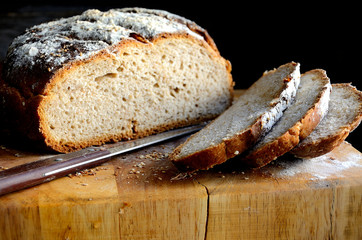 Sliced homemade rustic bread on a wooden table.