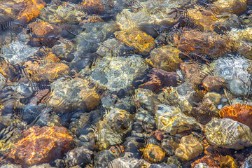Fototapeta na wymiar Colored Rocks Under Clear Water 4