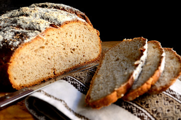 Sliced homemade rustic bread on a wooden table.