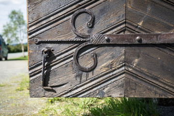 Detail of the door of the Kvikne Stave Church, a cruciform church dating from 1764 in the municipality of Nord-Fron in Oppland county, Norway. Thick wooden door has decorative forged details.