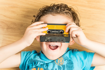 Child looking through the holes of a cassette tape