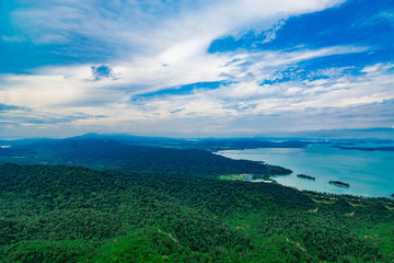 Fototapeta premium Aerial view of Langkawi island's forest and coastal area with blue sky background