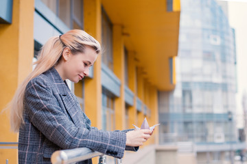 Young woman playing origami birds, white cranes in hands against sky reflection in a window