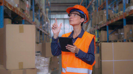 Woman working at warehouse. Female worker checking and counting up boxes for delivery. Employee...