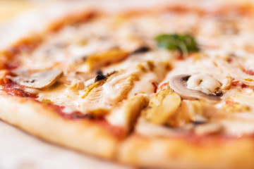 Pizza with chicken and mushrooms close-up in defocus