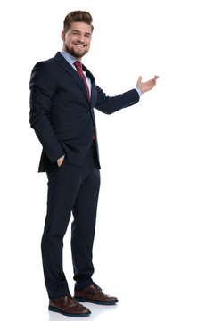 Positive businessman presenting and holding his hand in his pocket