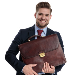 Jolly businessman holding his briefcase and smiling