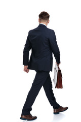 Rear view of a walking businessman holding his briefcase