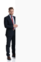 Attractive businessman holding a big empty billboard
