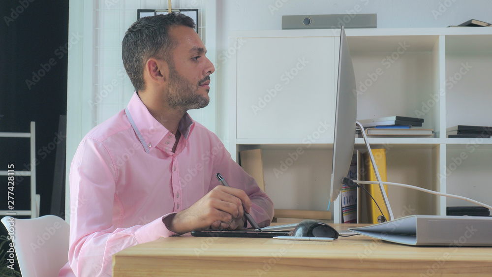 Aufkleber mixed race handsome designer working in modern creative office. Young man sitting in front of display computer drawing using digital tablet