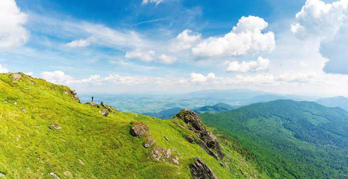 rock on the edge of a hill. view in to the valley. beautiful summer landscape of carpathian mountains. grass on the slope beneath a cloudy sky. borzhava ridge on the horizon, location mnt. pikui, UA