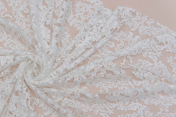 a background image of ivory-colored lace cloth. White lace on beige background.