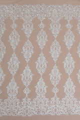Fototapeta premium a background image of ivory-colored lace cloth. White lace on beige background.
