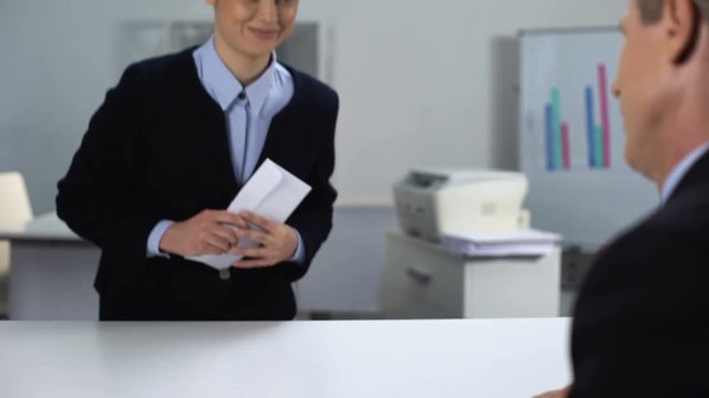 Businessman giving woman envelope, bribery concept, illegal business deal
