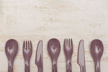 reusable plastic tableware on wooden background. ecological safety. nature preservation.