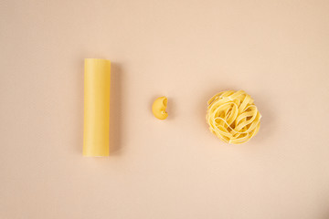 pene regate, tagliatelle and cannelloni pasta on beige background