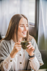 portrait of a beautiful girl with a Cup of coffee in a cafe