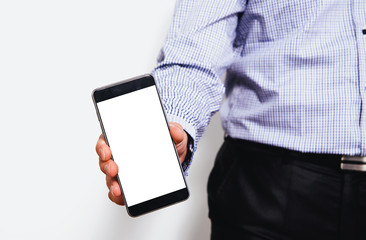 Phone in hand with a blank screen. A man dressed in a business shirt holds in his hand a phone with a blank display. Content completion concept.