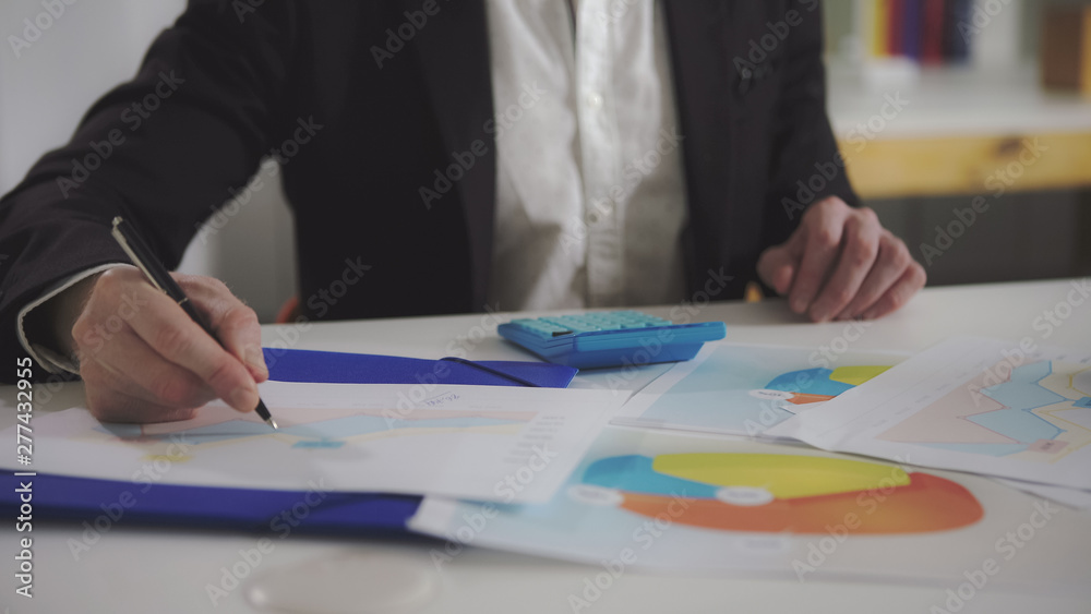 Leinwandbilder a man looks at the charts and checks them using a calculator. uhd