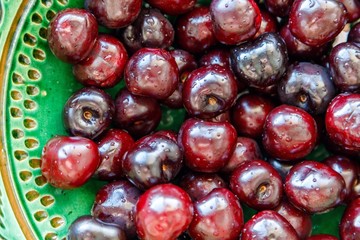 cherries ready to eat on a green platter
