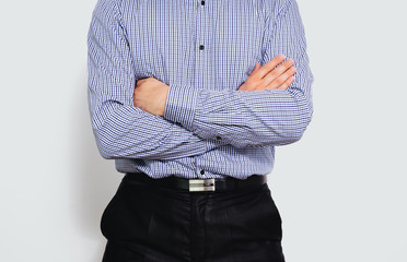 A man with his arms folded. A man dressed in a business shirt crosses his hands. Concept of self-confidence, expectations for good news, good luck in business.