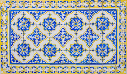 Traditional Portuguese ceramic tile with blue, floral motifs and a yellow frame