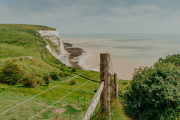 Amazing view of chalk White Cliff near green meadow. Top view. Aerial picture. Spectacular coastline landscape. Beachy head. Grassland England