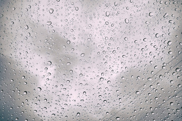 Rain drops visible on window. Autumn rain on the car glass, selective focus on raindrop.