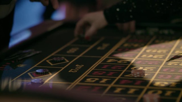 Casino croupier shuffling and dealing cards on table, poker game, roulette, people in casino, cards, gambling, closeup, hands, tokens / 4K Video Footage