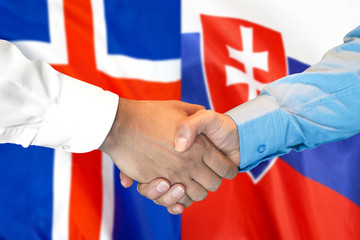 Fototapeta premium Business handshake on the background of two flags. Men handshake on the background of the Iceland and Slovakia flag. Support concept