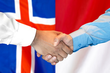 Business handshake on the background of two flags. Men handshake on the background of the Iceland and Monaco flag. Support concept