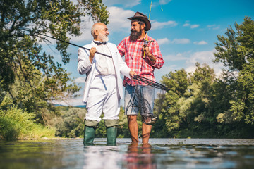 Happy family concept - father and son together. Fly angler on the river. Fishing in river. Man fishing. Generations men. Fishing became a popular recreational activity.