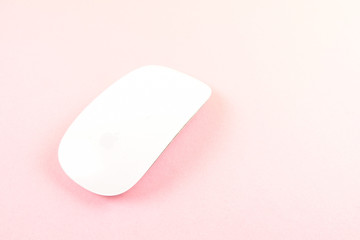 White laptop mouse over pink background.