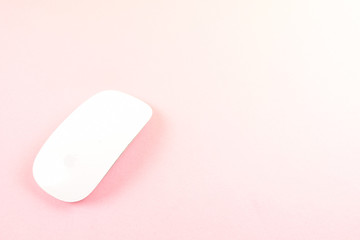 White laptop mouse over pink background.