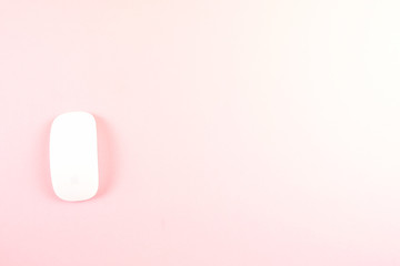 White laptop mouse over pink background.
