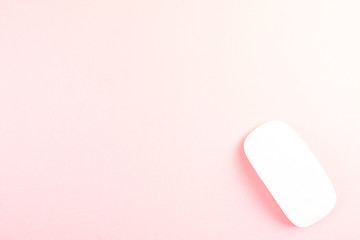 White laptop mouse over pink background.