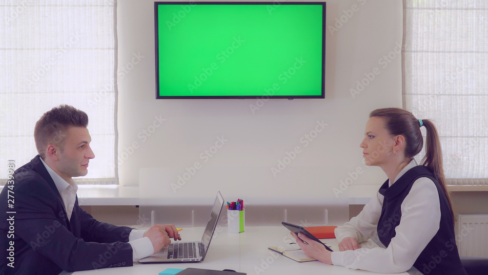 Aufkleber business partners discussing project. adult workers sitting in office on wall monitor with green scr