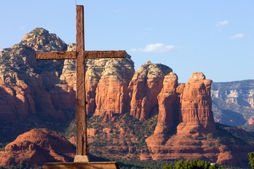 A wood cross with the red rock mountains of Sedona, Arizona..