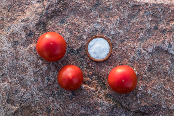 Fresh. red tomatoes on the background of granite stone. Summer evening.