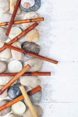 Vertical SPA flat lay. Dry bamboo, sea pebbles, scented candles, sea salt on a light wooden background. Top view