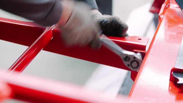 Human hands tighten nut with adjustable wrench with nozzle. Assembly of unit