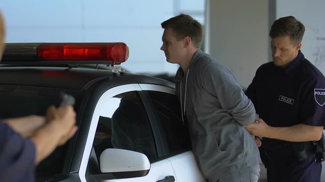 Group of cops arresting male bandit, woman aiming gun at dangerous criminal