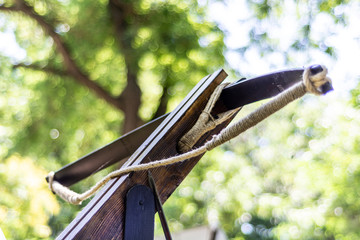 Medieval old big crossbow without an arrow in nature and blurred green background. Medieval war equipment concept. Close up, selective focus