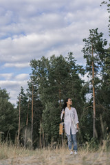 Happy Korean girl holding canvas, paint brush, box easel, enjoying beautiful landscape, breathing fresh air, relaxing in park. Asian woman artist walking, looking for inspiration outdoors