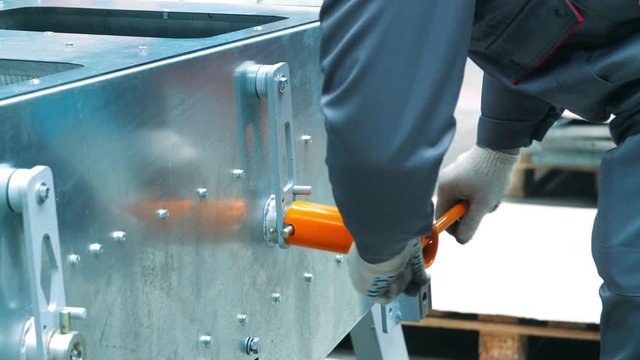 Worker securing bolts with wrench with t-handle. Mechanic tightening bolts