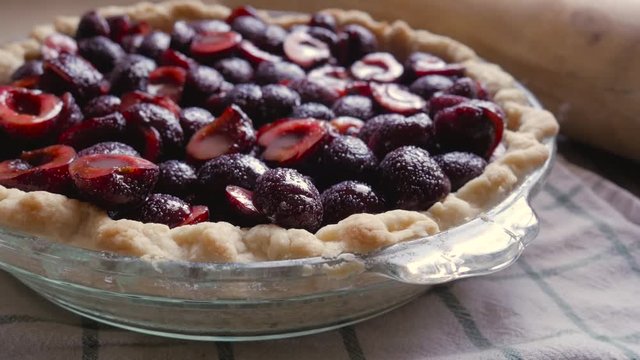 Closeup Of A Fresh Cherry Pie On A Kitchen Counter In 4k. Bright Red Stone Fruit Fills The Homemade Pie Crust Waiting To Be Baked. Natural Light Fills The Rustic, Summertime Shot.