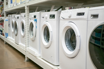 Row of washing machines in mall or store, selective focus